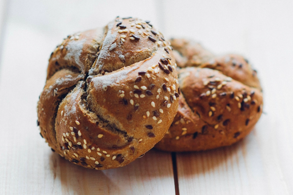 Fresh-baked loaves of bread on a wooden board